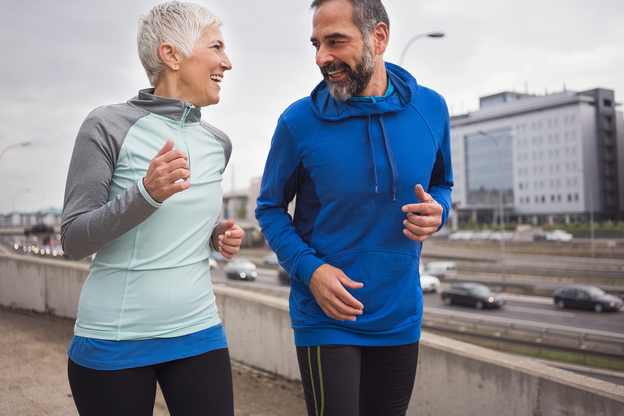 Couple jogging together on an urban pathway.