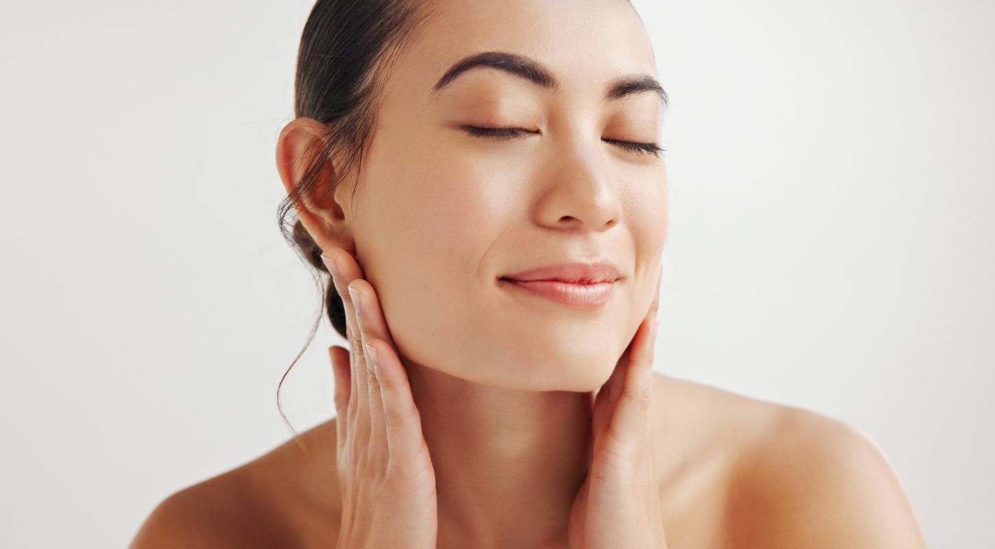 Young woman enjoying skincare routine with closed eyes